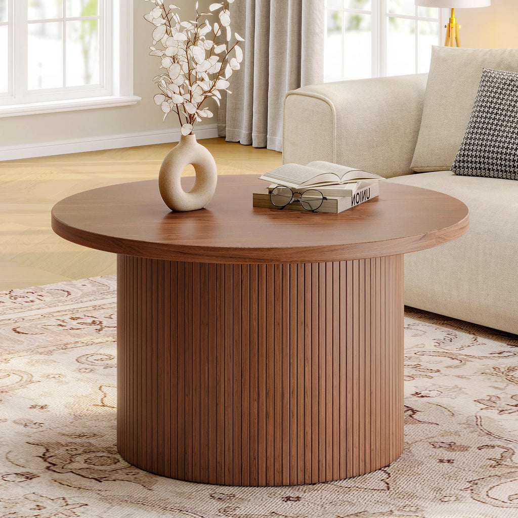 Daydreamarc drum coffee table centered on a patterned rug beside a sofa