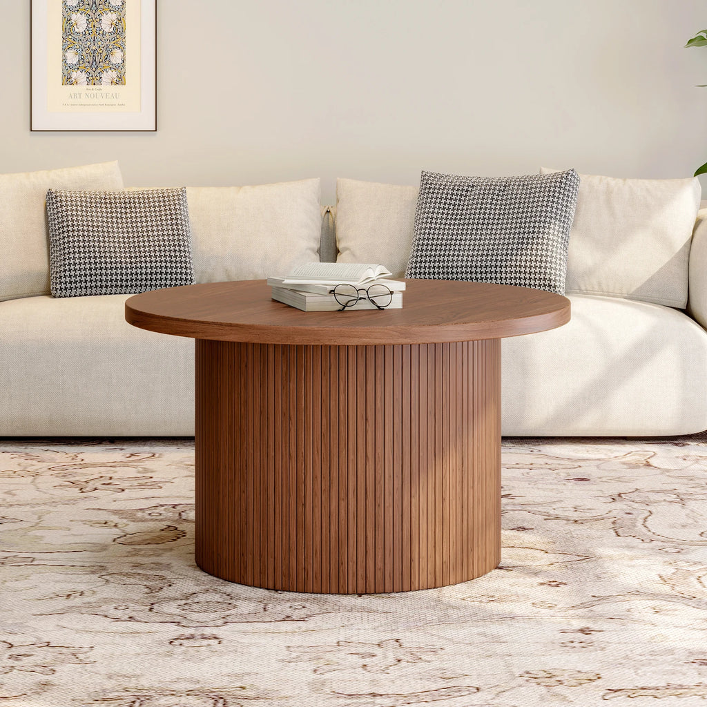 Walnut-finish Daydreamarc round coffee table shown in front of a sofa