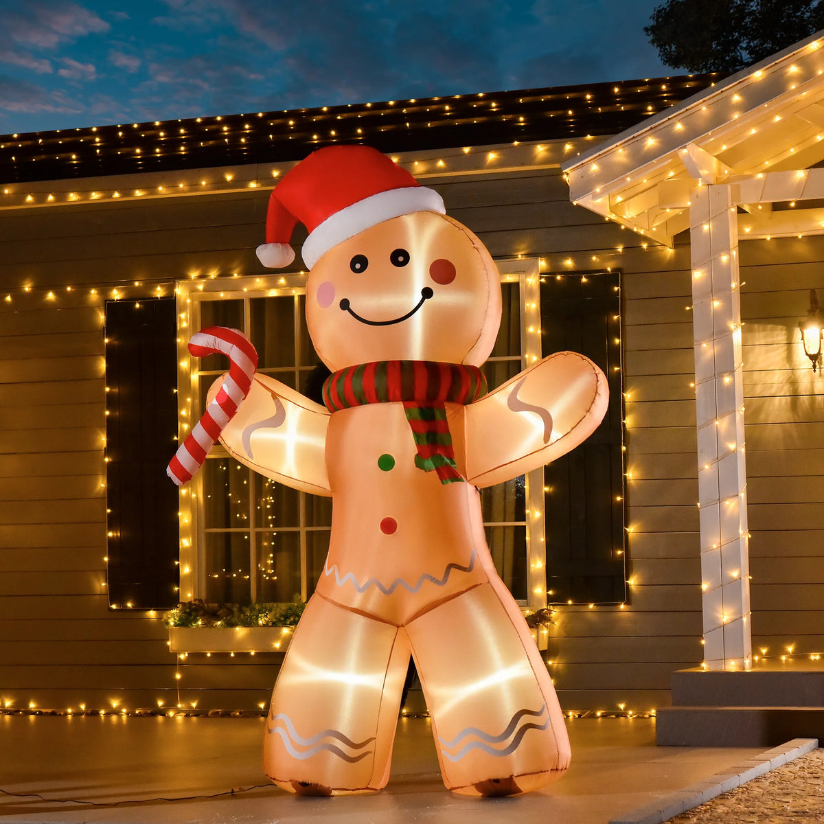 Gingercheer gingerbread inflatable illuminated beside a Christmas-decorated porch