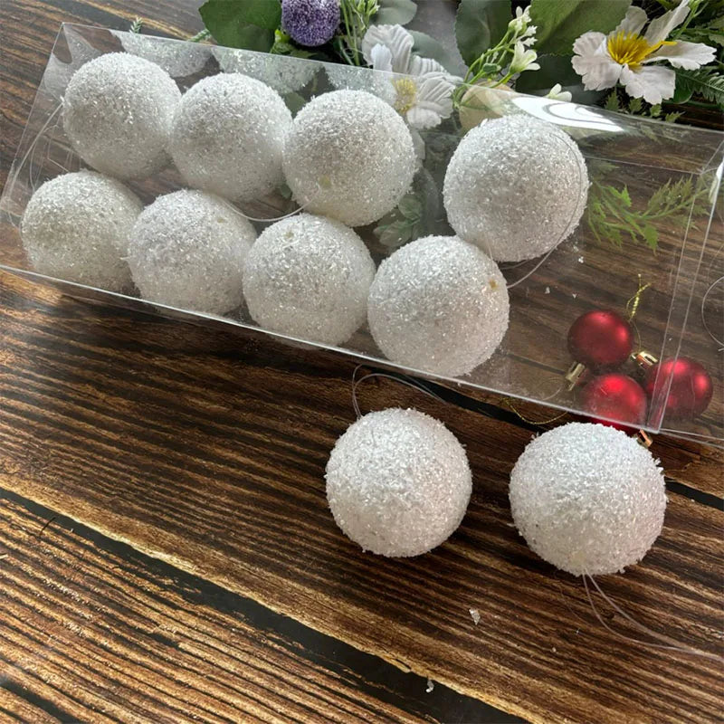 White sugar-coated Christmas ball garland lights in a clear plastic package, with two loose balls displayed on a dark wooden surface.