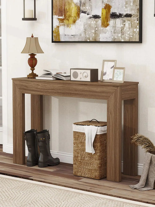 Amberarc Walnut console table holding lamp and framed art above open floor space