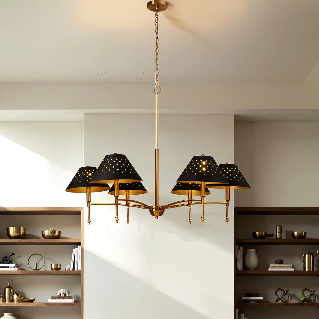 Chandelier with black lampshades and gold fixture hanging in a room with shelves.