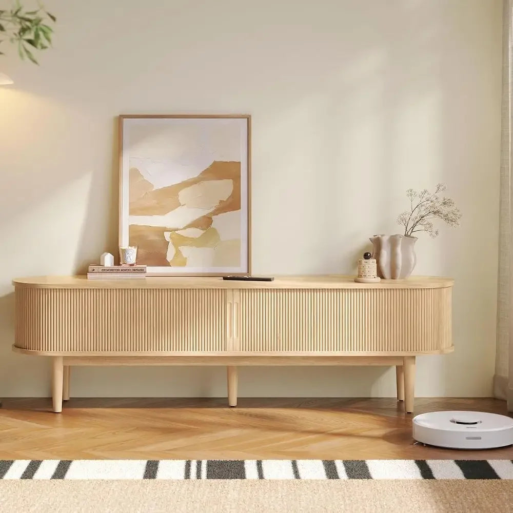 Wenselle blonde wood-look media console on high legs with decor displayed