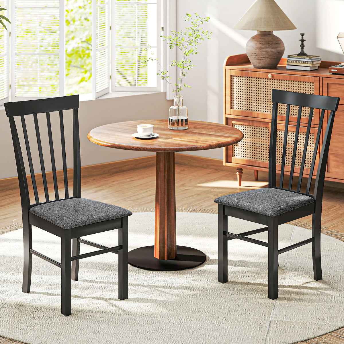 Two black and gray Novacrest dining chairs beside a round wooden table