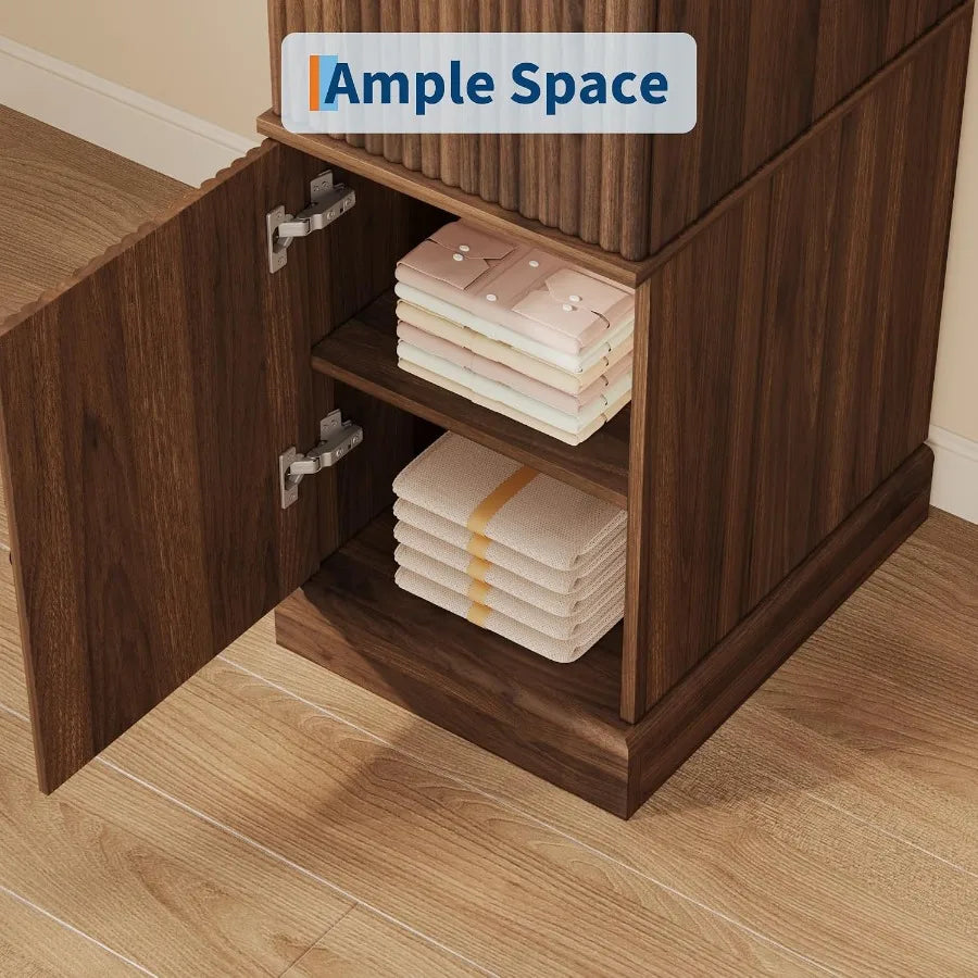 Open lower cabinet compartment with a dividing shelf holding folded shirts and towels.