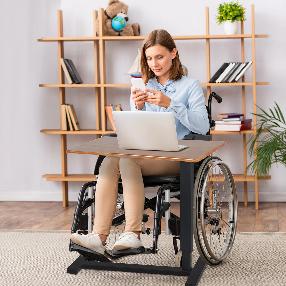 Adjustable table positioned as a work surface in front of a wheelchair