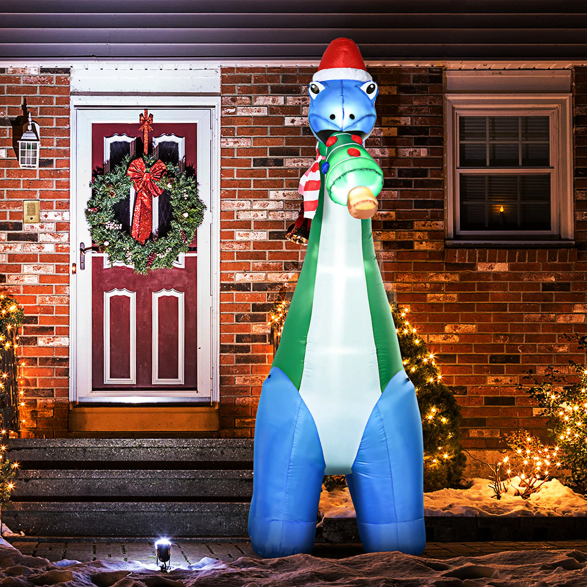 Merrysaurus blue-and-green Christmas dinosaur inflatable lit outside a holiday entrance