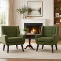 Two green button-tufted accent armchairs arranged beside a fireplace
