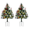 Snowberry set of two pre-lit entryway Christmas trees with snowy tips, berries, pinecones, and red ornaments
