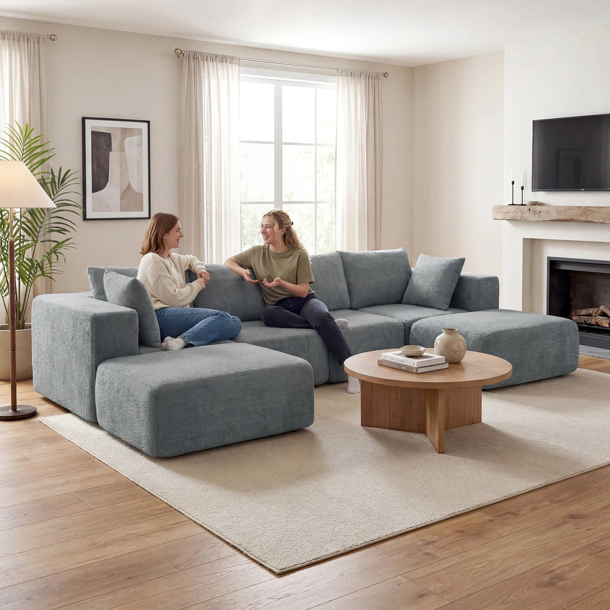 Dark gray Valegrove sectional shown with two people in a living room