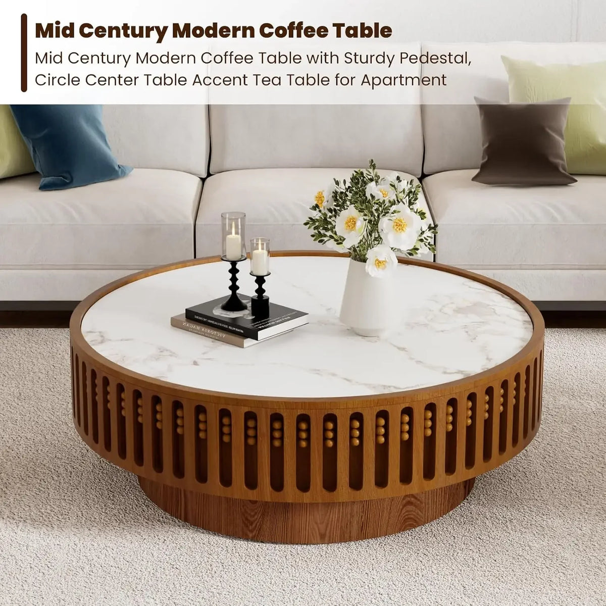 Orelia larger round coffee table styled in front of a sofa with books, candles and flowers