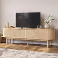 Natural wood-look Wenselle fluted TV stand with television above long rounded cabinet