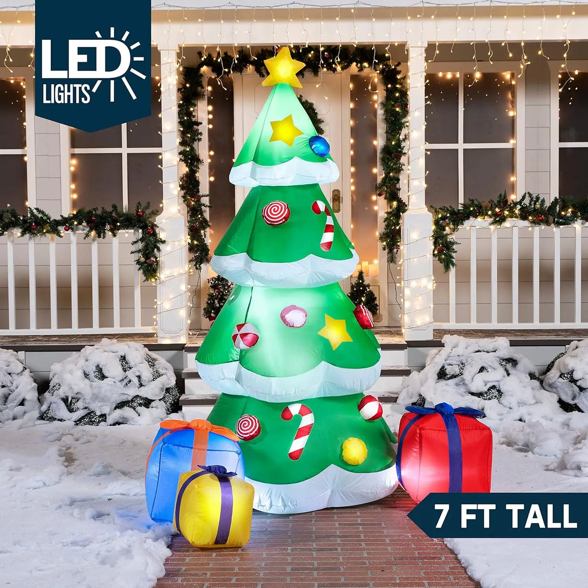 Tinselglow green Christmas tree inflatable with a star and three colorful gift-box accents in a snowy yard.