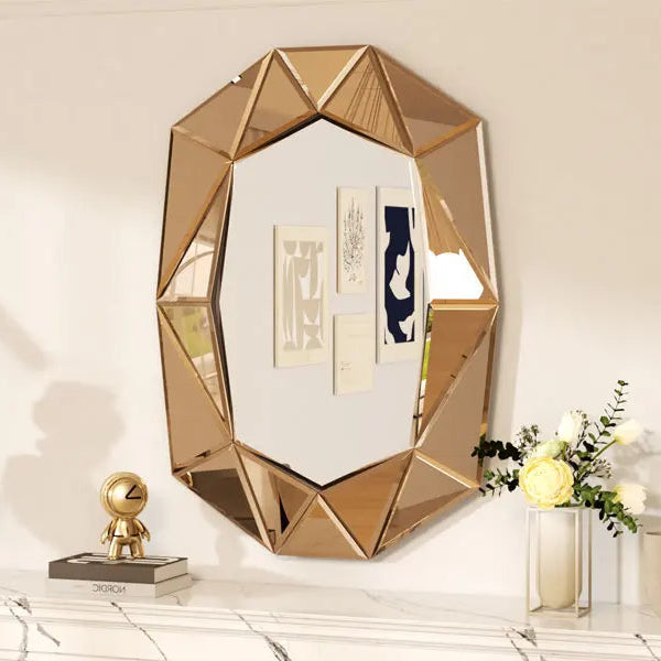 Geometric gold mirror on a decorative shelf with a white wall background