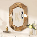 Geometric gold mirror on a decorative shelf with a white wall background