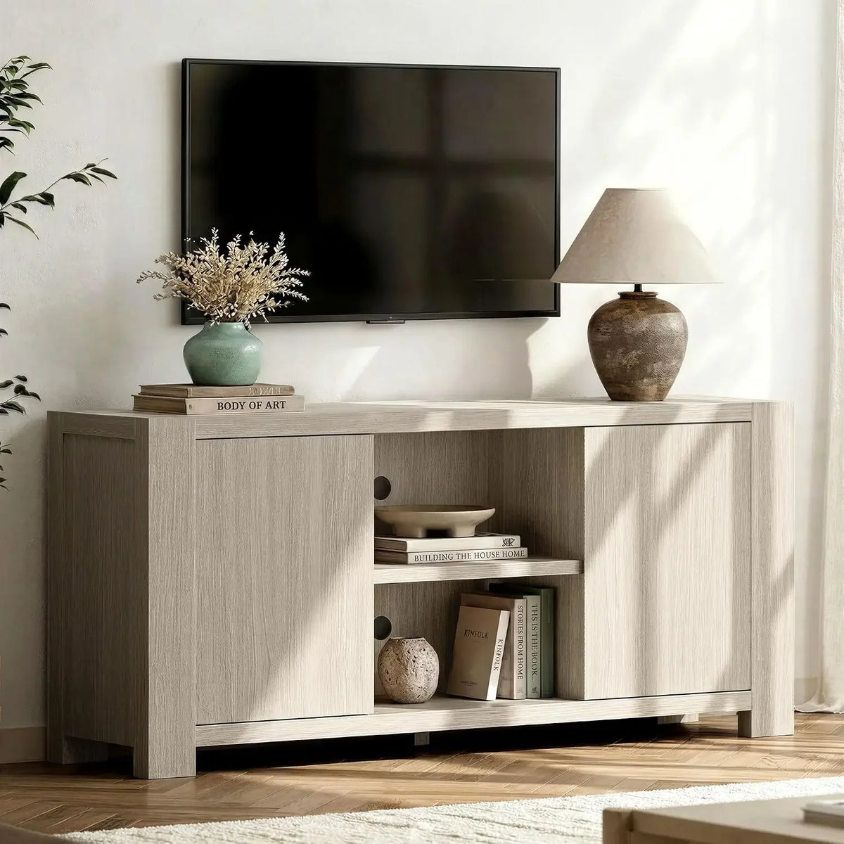 Mellorin pale wood-look media console with two handle-free doors and open center shelving.