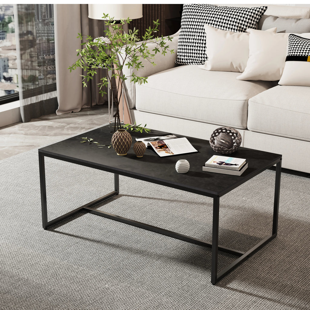 Black coffee table with a slim rectangular top and open frame, shown with a tall vase and decorative objects.