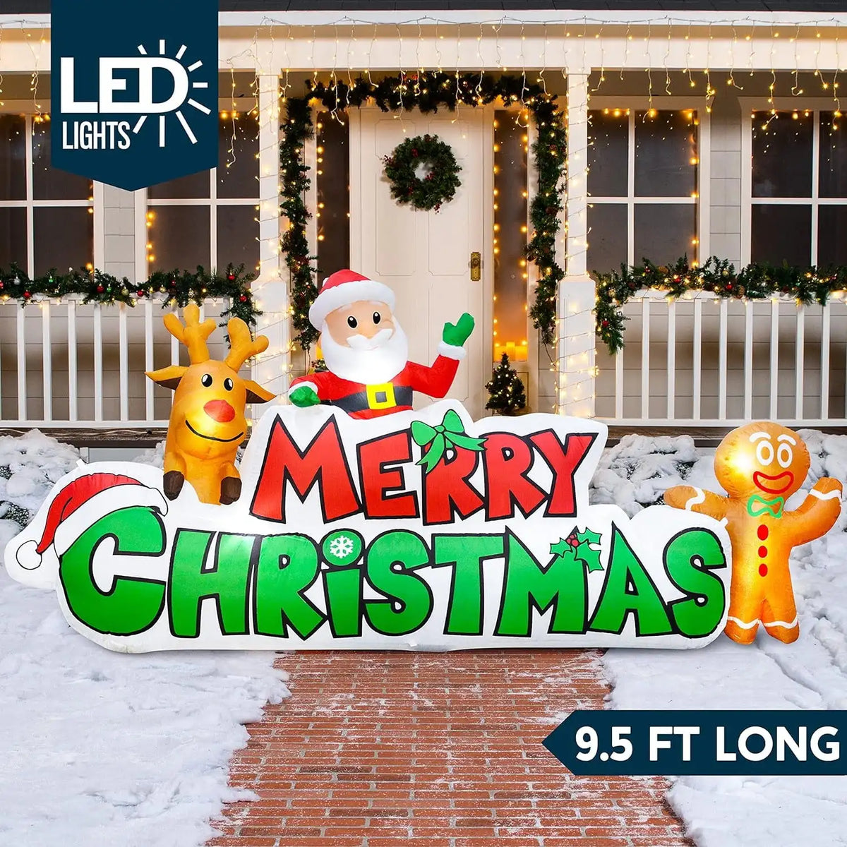 Merriglow Merry Christmas sign inflatable with Santa, reindeer and gingerbread characters illuminated outdoors.
