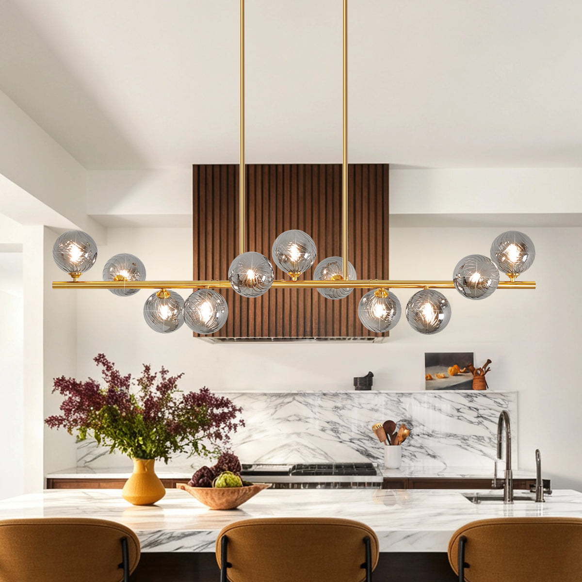 Orbstem gold-tone linear fixture with glass globes arranged above and below the bar.