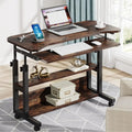 Wooden desk with laptop, keyboard, and other items in a home office setting.
