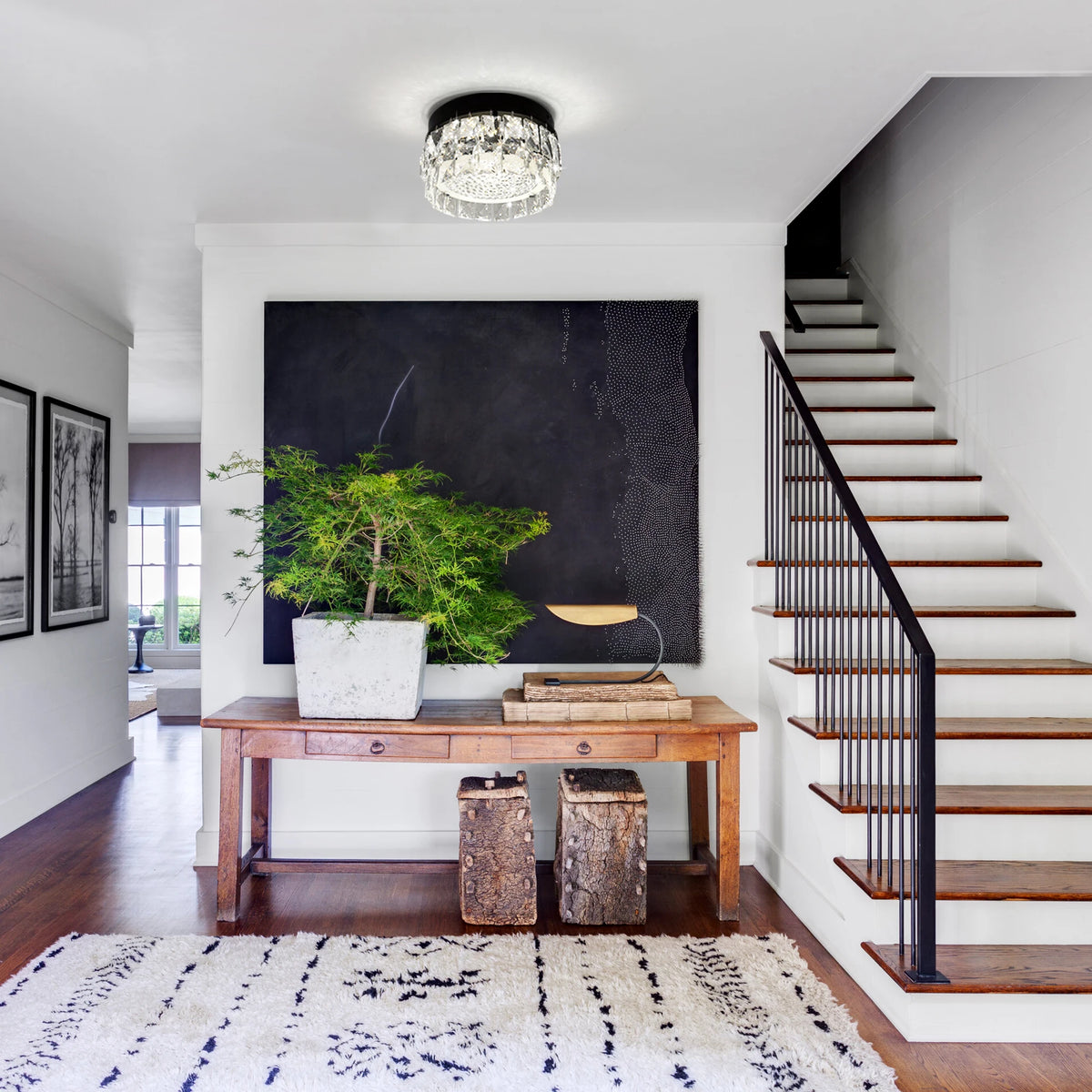 Glacielle: Round black ceiling light installed above an entryway console table