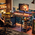 Black computer desk staged with a monitor and tower on its lower shelf