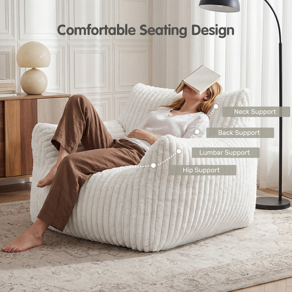 A woman reclines on a large white ribbed lounge chair in a bright living room. Text at the top reads 'Comfortable Seating Design,' with callouts indicating neck support, back support, lumbar support, and hip support.