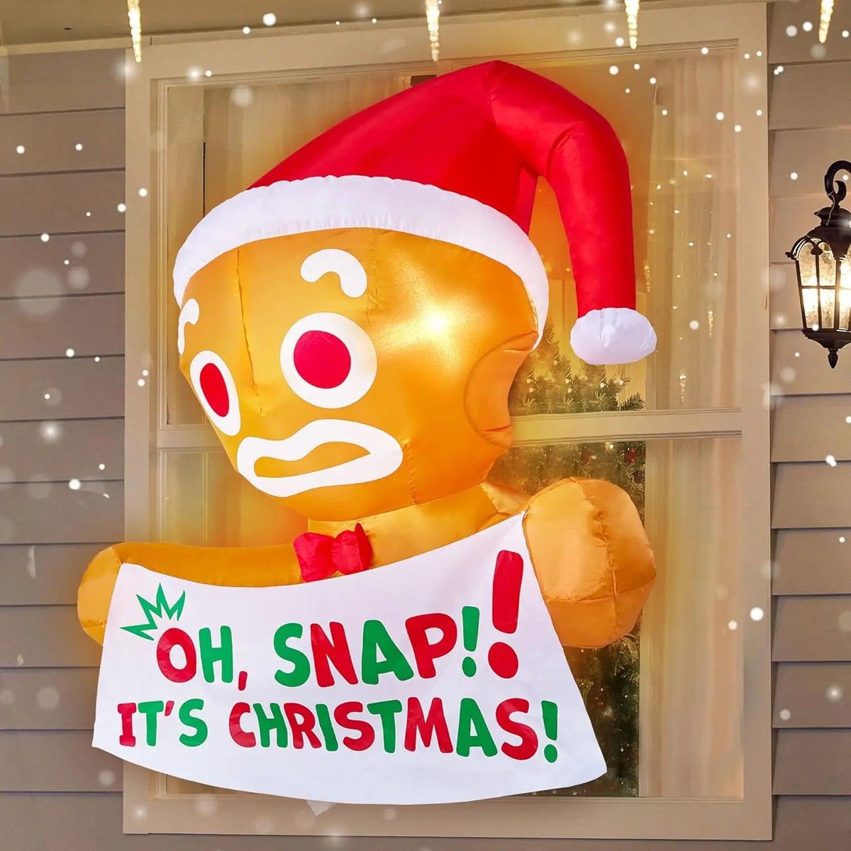 Gingerpeek gingerbread window inflatable holding an Oh, Snap! It's Christmas! banner.