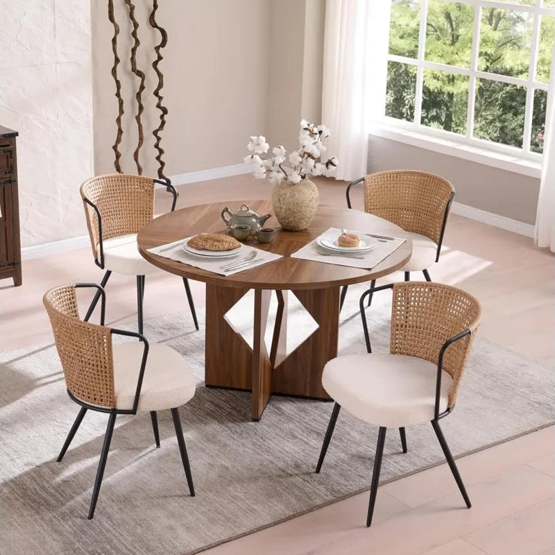 Dining room with a round wooden table and chairs in a well-lit room.