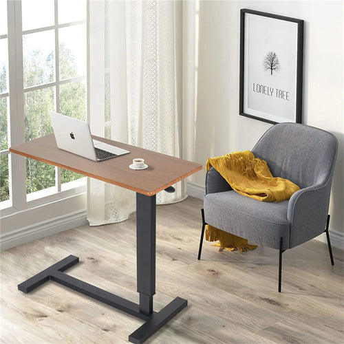 Adjustable oak-look side table holding a laptop beside an upholstered chair