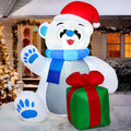 Giftpaw seated polar bear inflatable with raised paw, Santa hat, blue scarf and green gift.