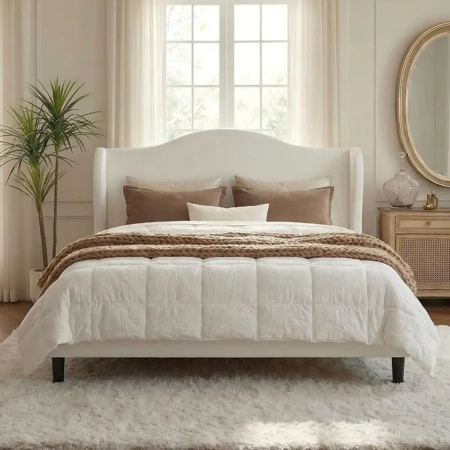 Straight-on view of the upholstered bed with softly arched headboard and dark exposed legs.