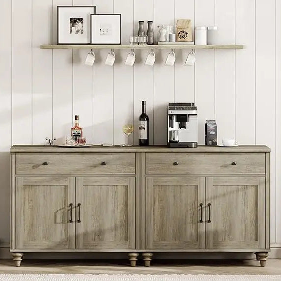 Wooden sideboard with kitchen appliances and decor items against a white paneled wall.
