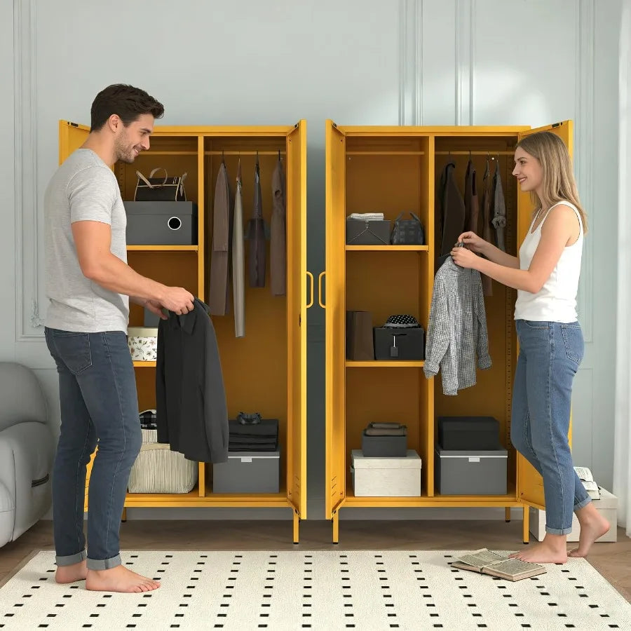 Two yellow wardrobes staged side by side with people arranging clothes.