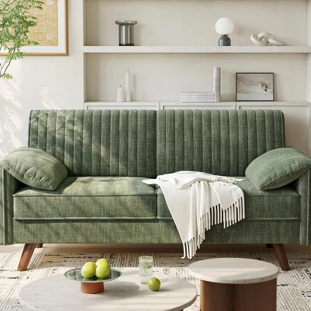 Green sofa in a living room with a coffee table and decorative items.