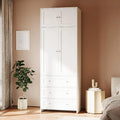 Tall white wardrobe with four paneled doors, three lower drawers and clear round knobs.