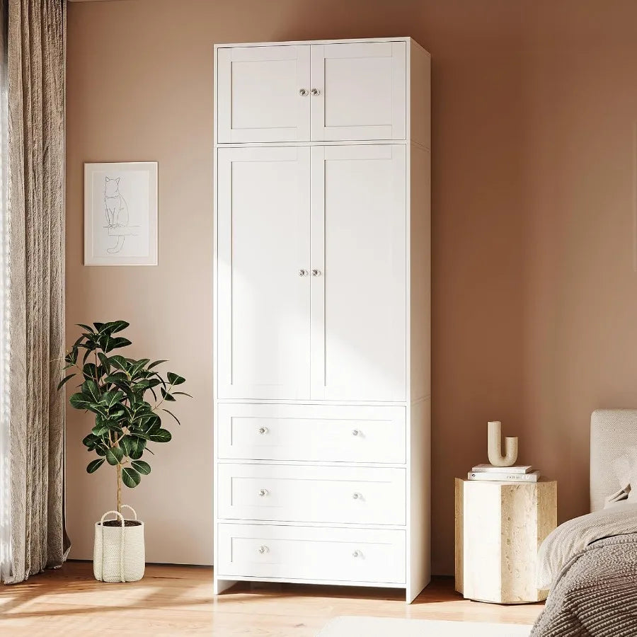 Tall white wardrobe with four paneled doors, three lower drawers and clear round knobs.