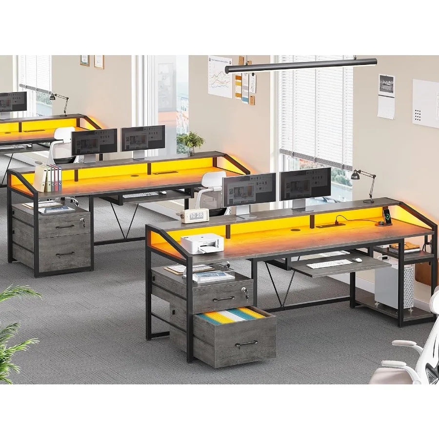 Office layout showing three gray desks with warm lighting and drawer storage; each desk is pictured as a separate workstation.