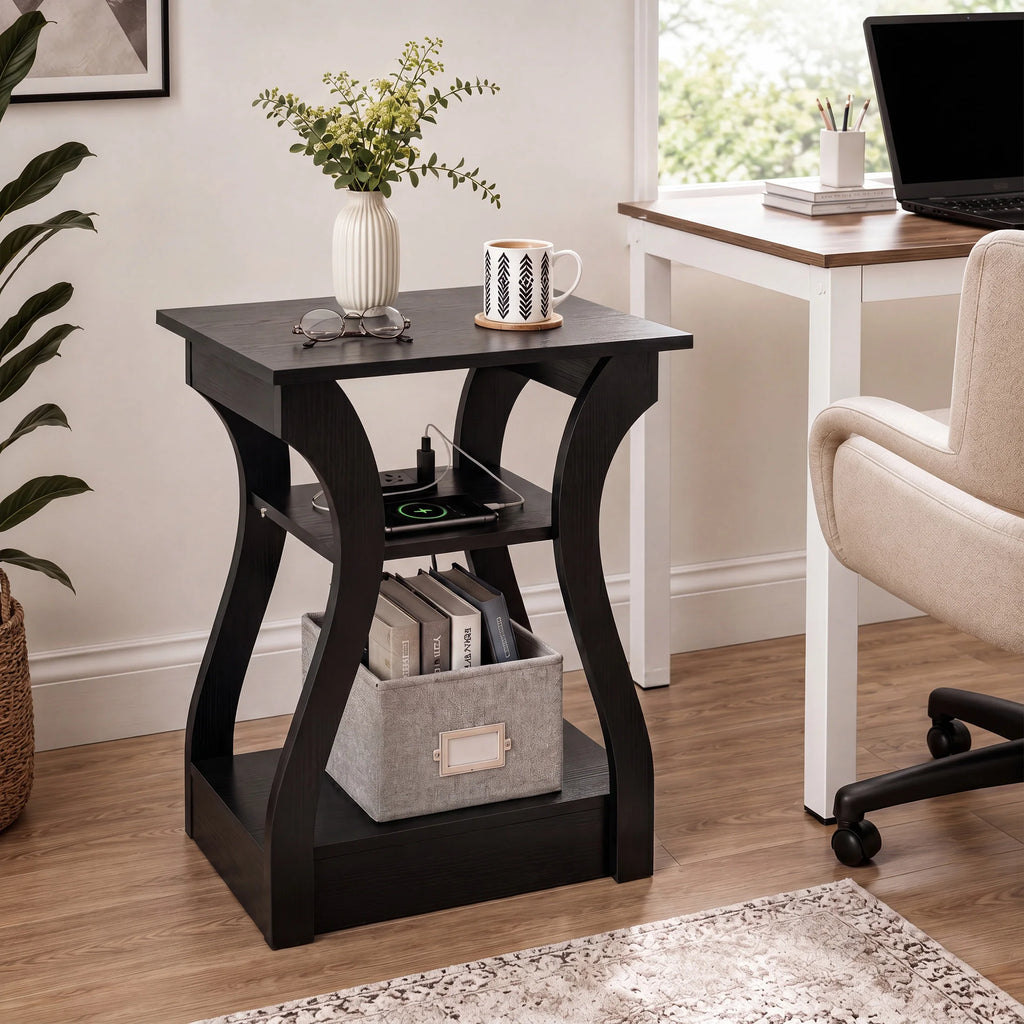 A black wooden end table with curved legs and a top shelf, styled in a home office setting next to a desk and chair.