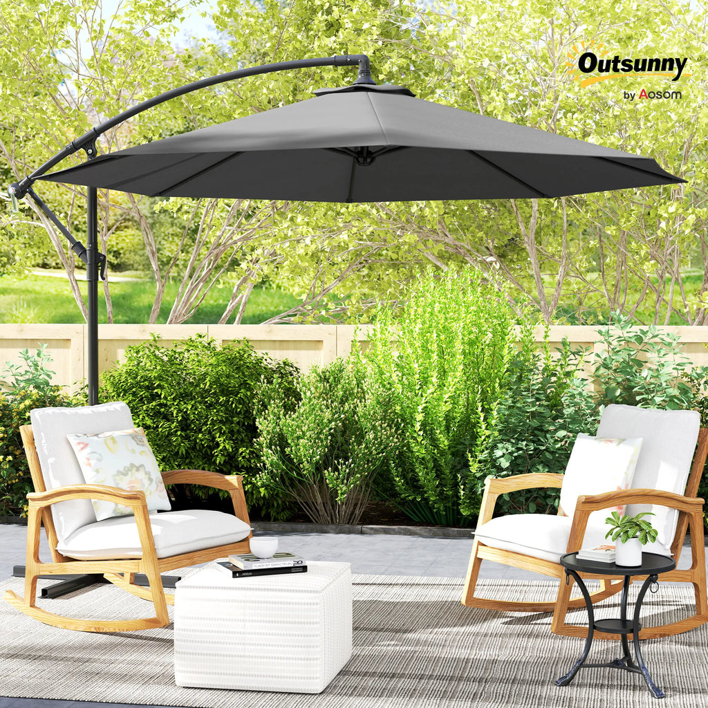 Gray cantilever patio umbrella shading two chairs in an outdoor garden seating area