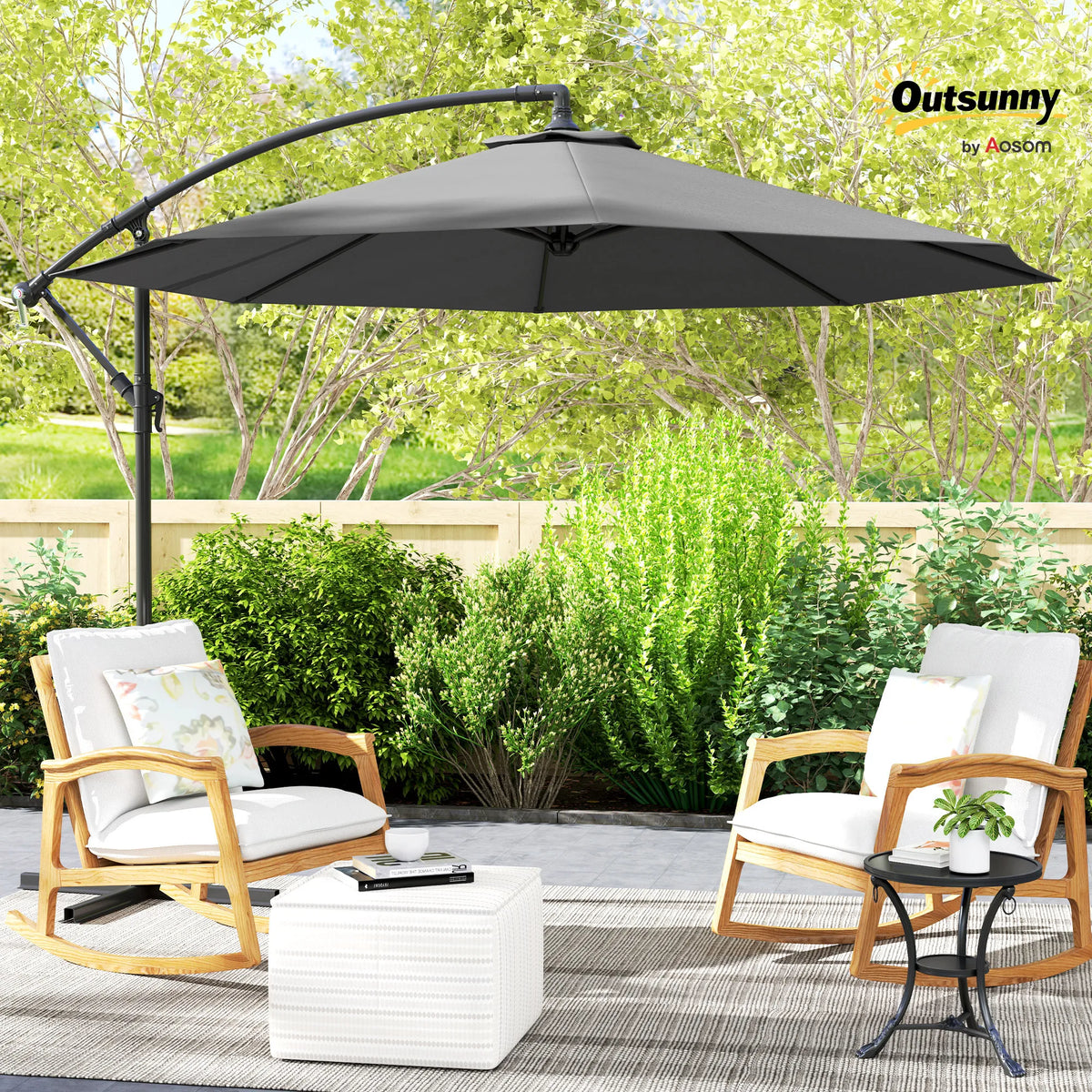 Gray cantilever patio umbrella shading two chairs in an outdoor garden seating area