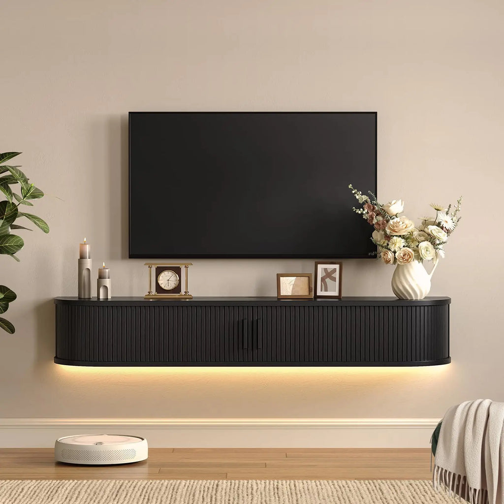 Black Calyxcrest floating TV cabinet with closed fluted doors and warm underside lighting.