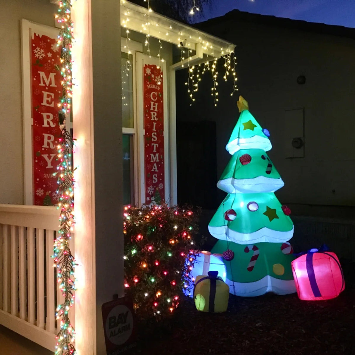 Tinselglow green inflatable tree styled near a home entrance.