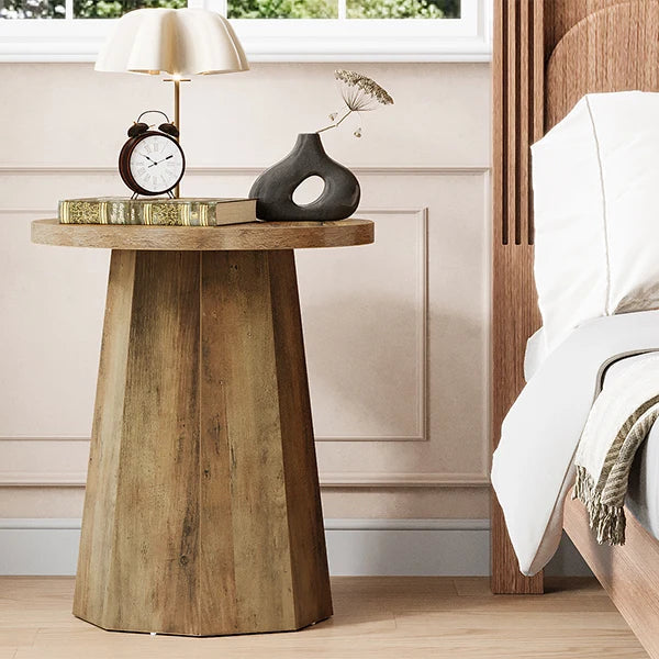 Wooden side table next to a bed in a bedroom setting