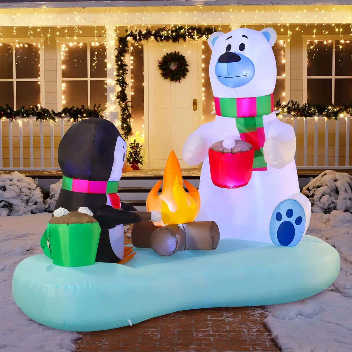 Cocoafrost connected polar bear and penguin Christmas scene glowing after dark.
