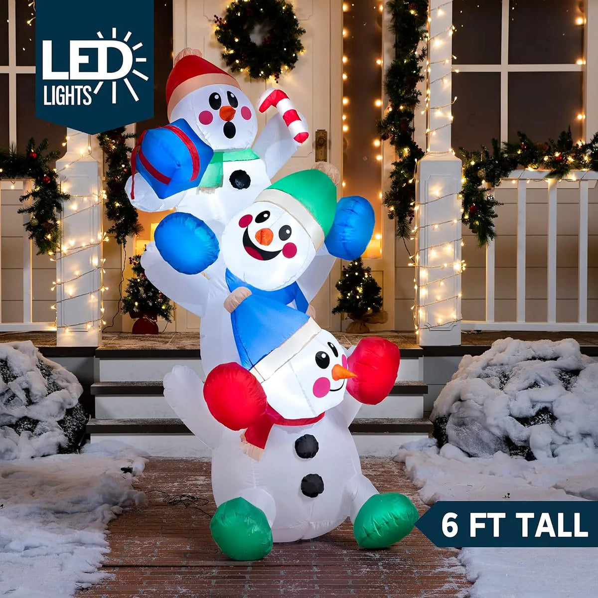 Snowtumble stacked-snowmen inflatable illuminated at night with a six-foot height label.