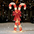 Bowglint crossed red-and-white candy canes with a red bow illuminated by warm white lights.