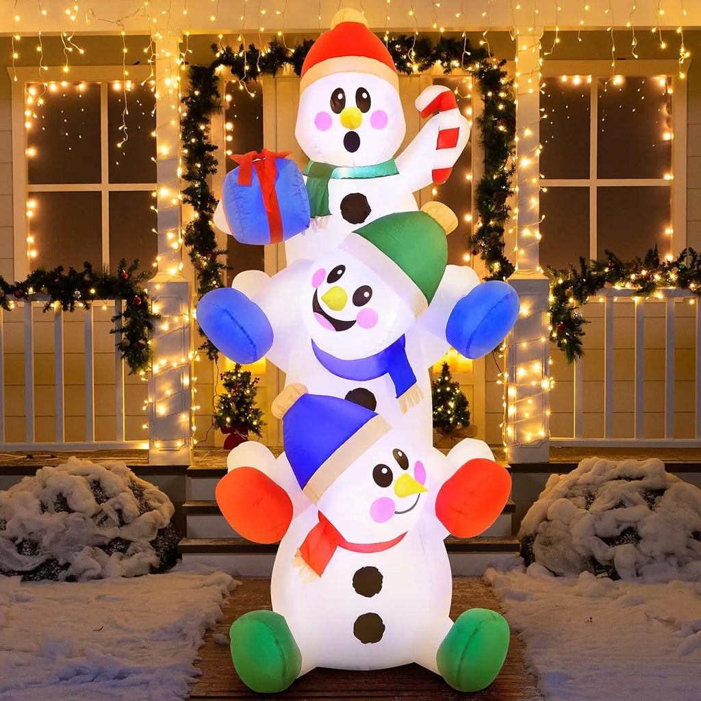 Snowtumble snowmen with red, green and blue accessories glowing in an evening holiday display.