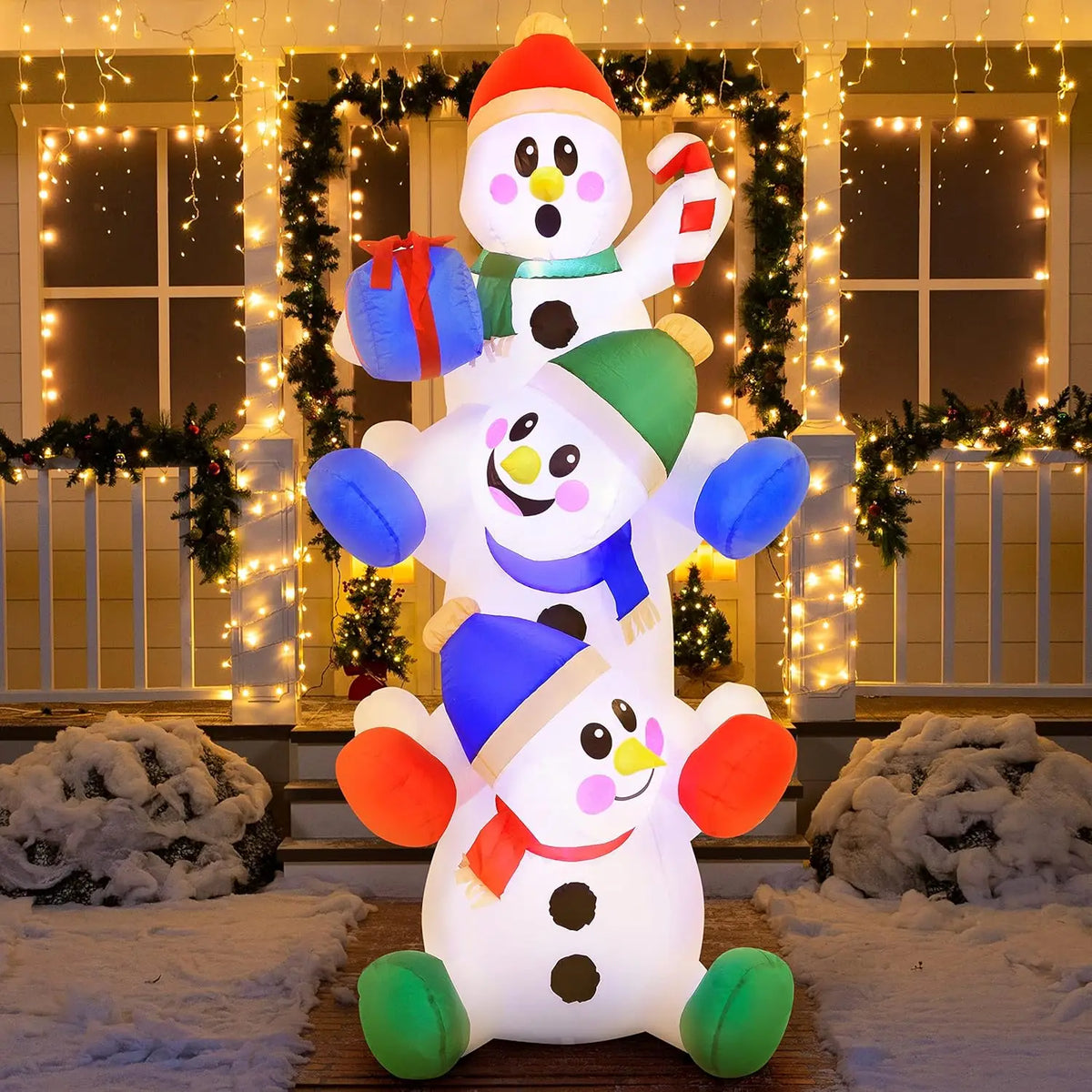 Snowtumble snowmen with red, green and blue accessories glowing in an evening holiday display.