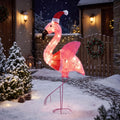 Rosalume lighted pink flamingo with a Santa hat and raised wing in a snowy holiday yard